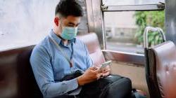 Young business man using smartphone on bus