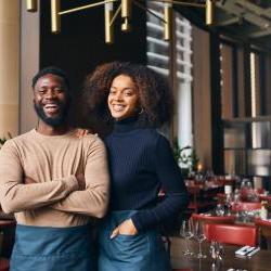 man and woman business partners stand in front of cafe together